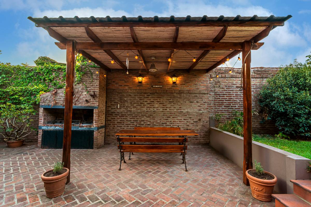 pergola with hanging chairs installed under a wooden backyard pergola with reinforced beams